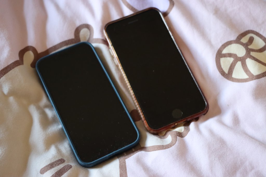 A photo of an iPhone 13 Mini (left) next to an iPhone 8 (right)