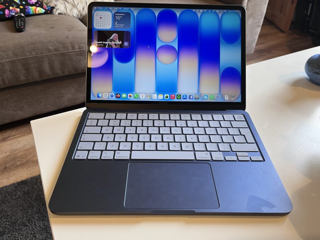 An Apple MacBook Neo open showing the standard desktop and keyboard