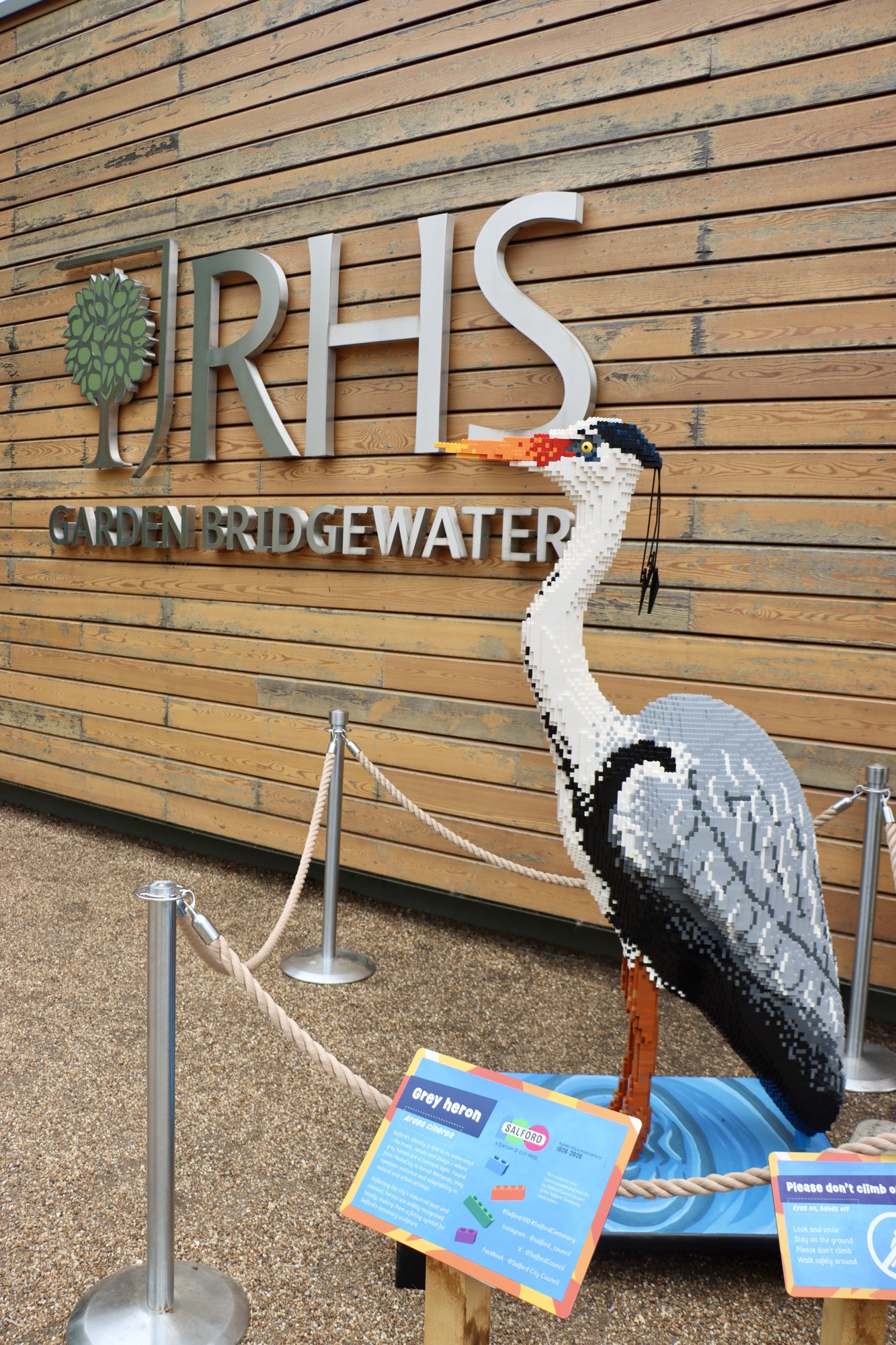 A photo of the entrance pavilion to RHS Garden Bridgewater, with a Lego brick Heron model